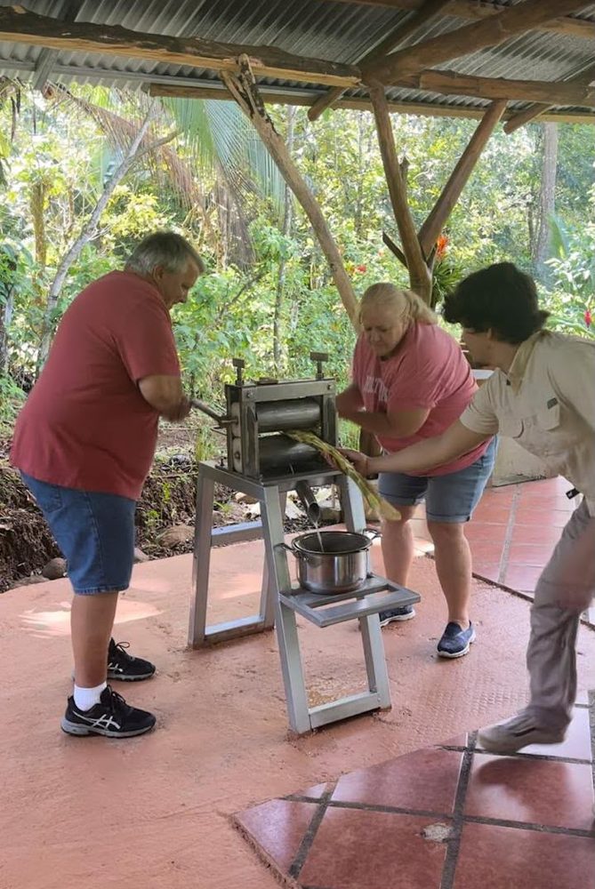 Prensando caña de azúcar a mano como parte del taller de cacao